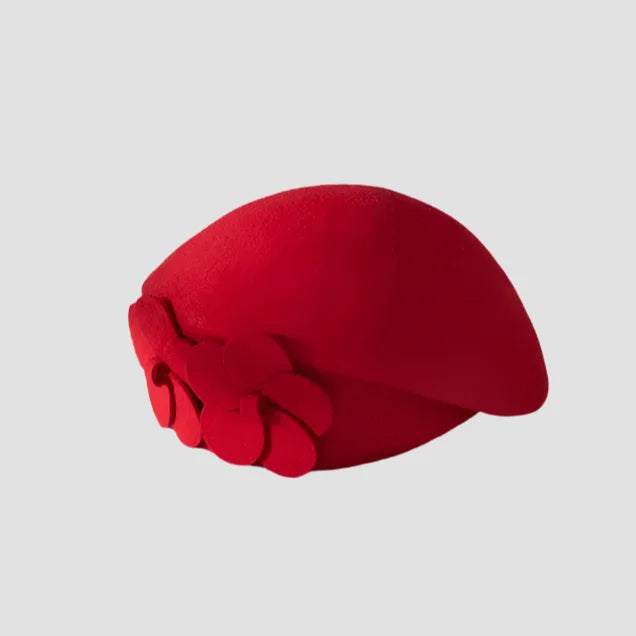 Red pillbox hat with floral detail.