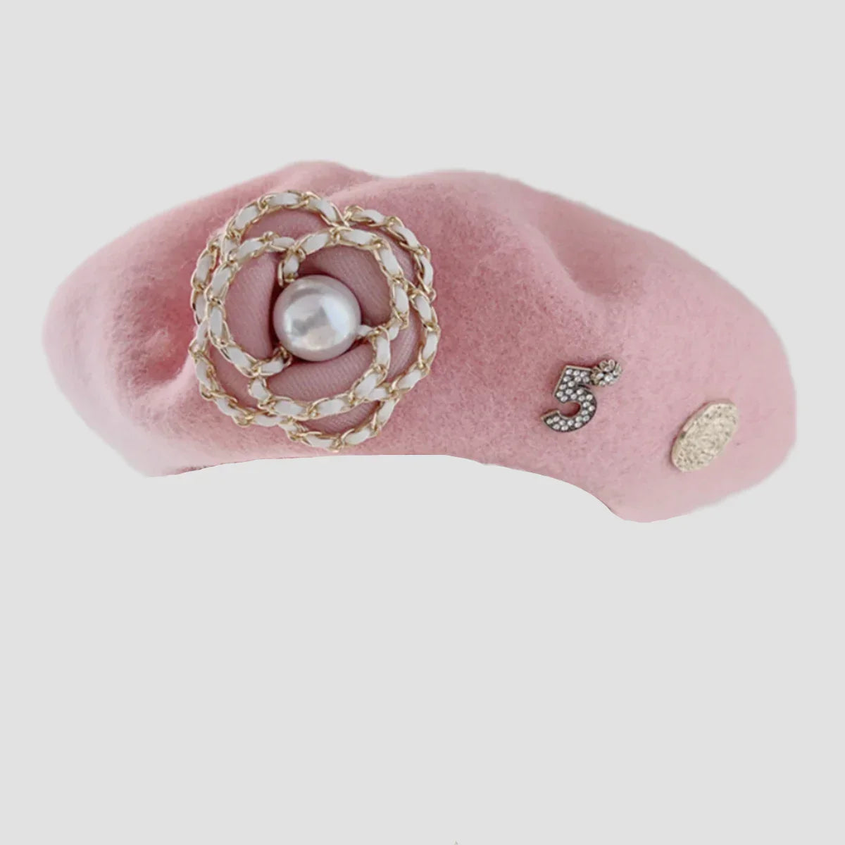 Pink beret with floral and number embellishments.