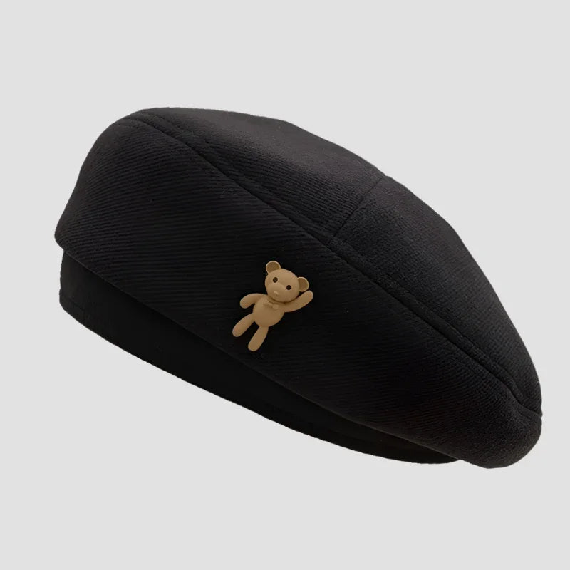 Black beret with teddy bear accent.
