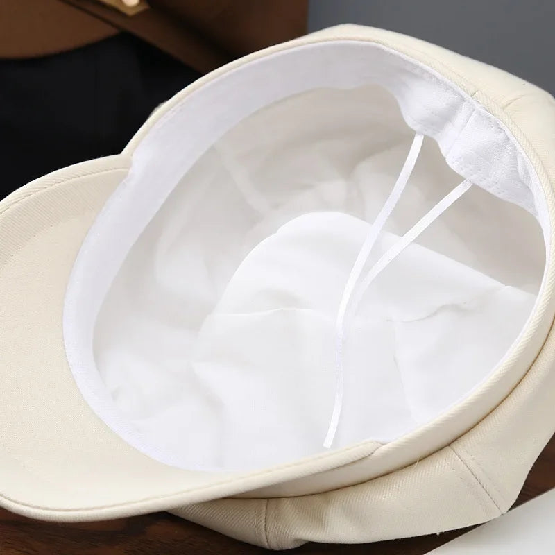 Beige baker boy hat.