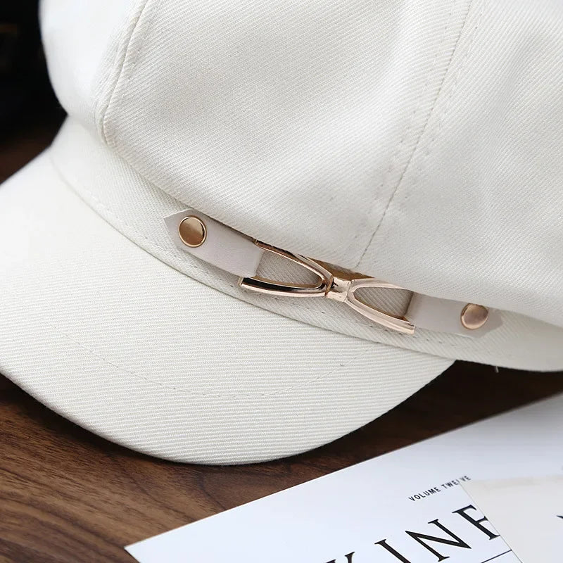 White cap with decorative strap.