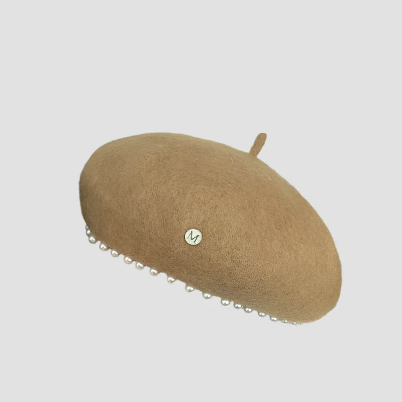 Beige beret with pearl trim.