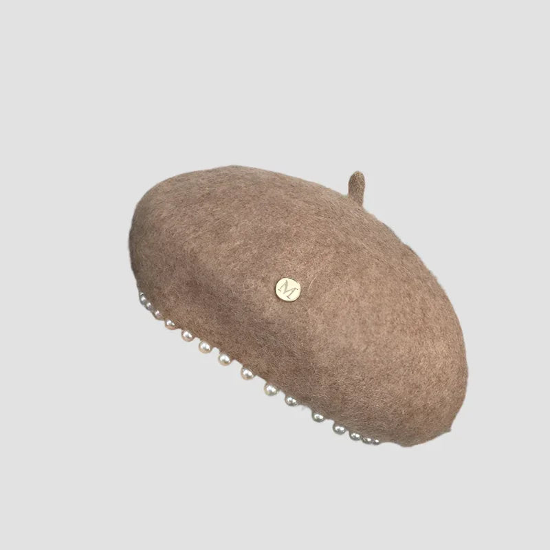 Beige beret with pearl trim.