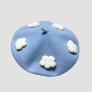 Light blue beret with white cloud accents.