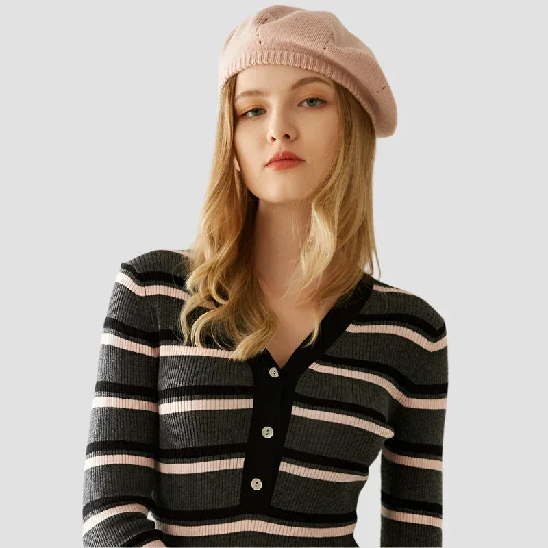 Woman wearing a pink beret and striped sweater.
