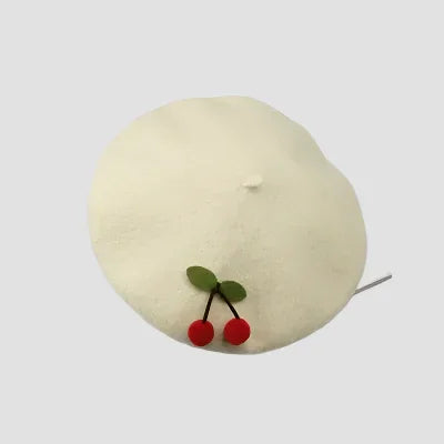 Cream-colored beret with cherry embellishments.
