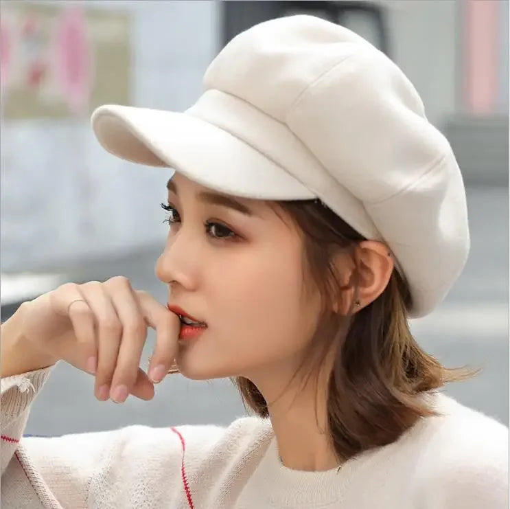 Woman wearing a white newsboy cap.