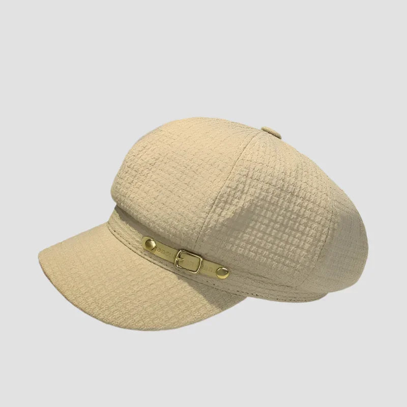 Beige newsboy cap with buckle.