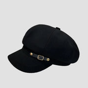 Black newsboy cap with buckle detail.