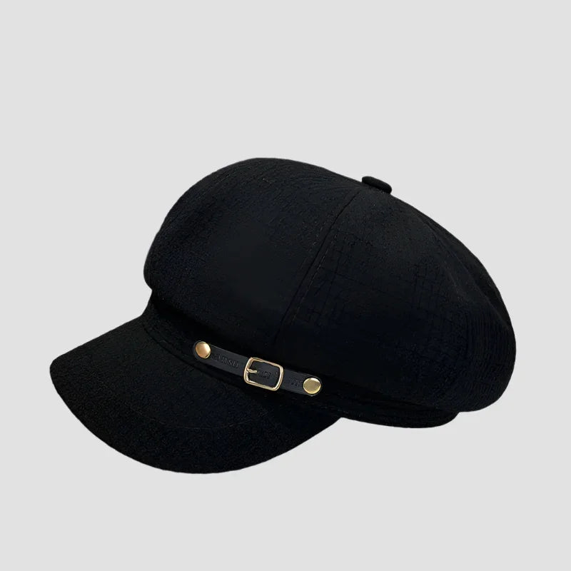 Black newsboy cap with buckle detail.