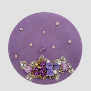 Lavender beret with floral embellishments.