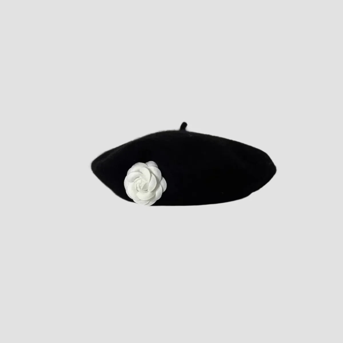 Black beret with white flower.