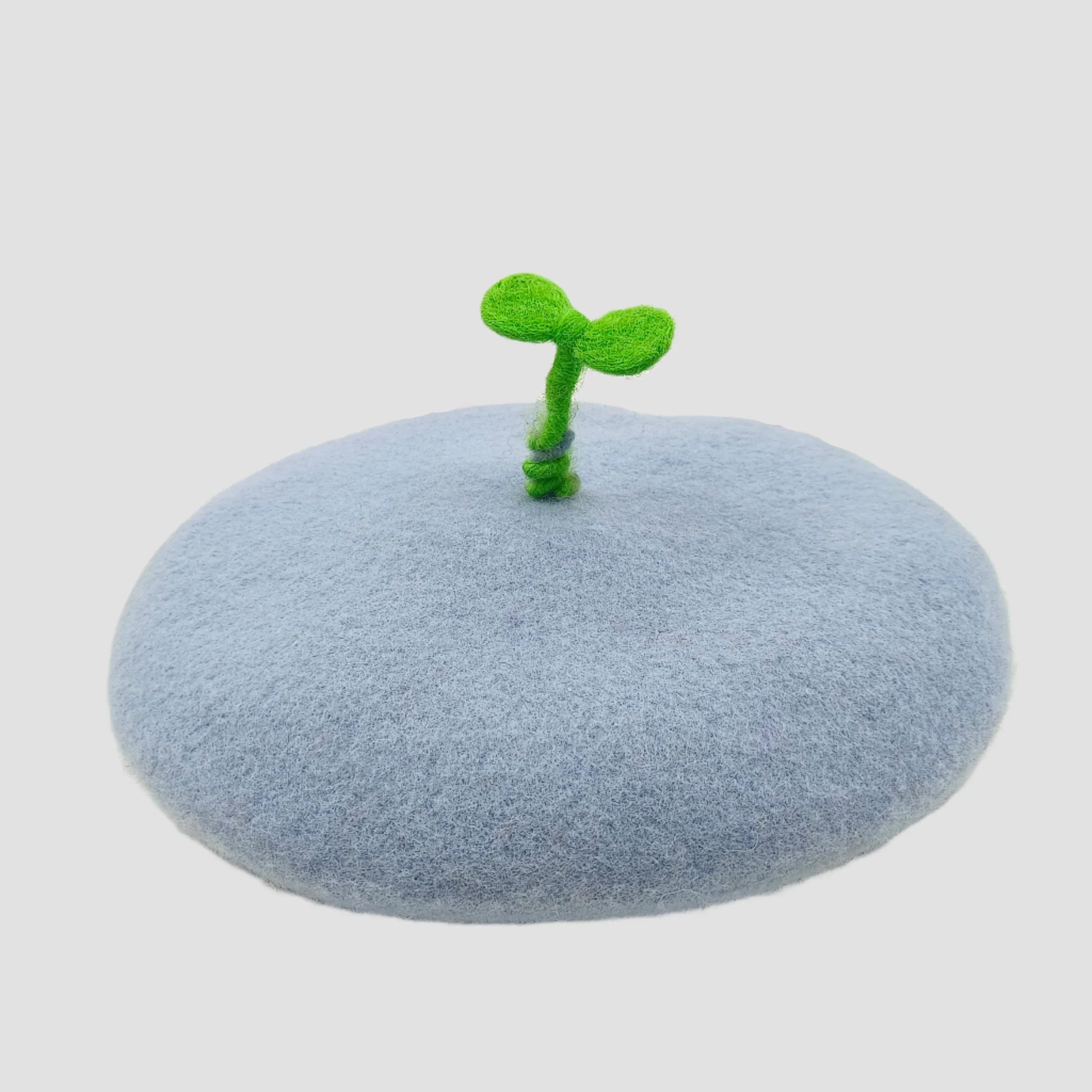 Light blue beret with green sprout.