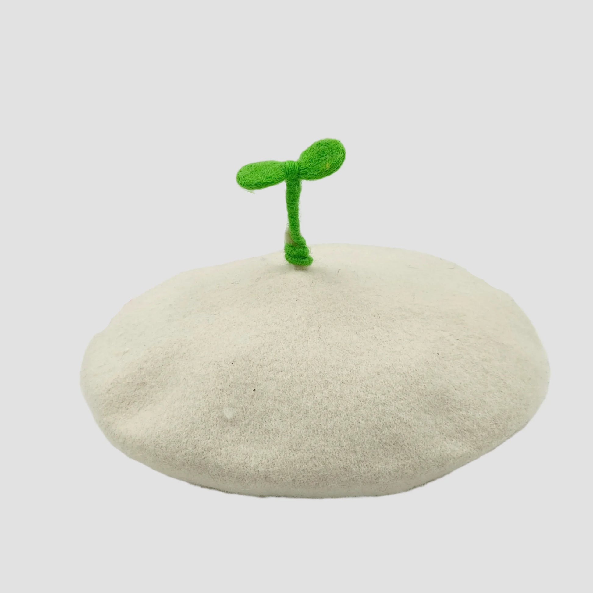 White beret with green sprout.
