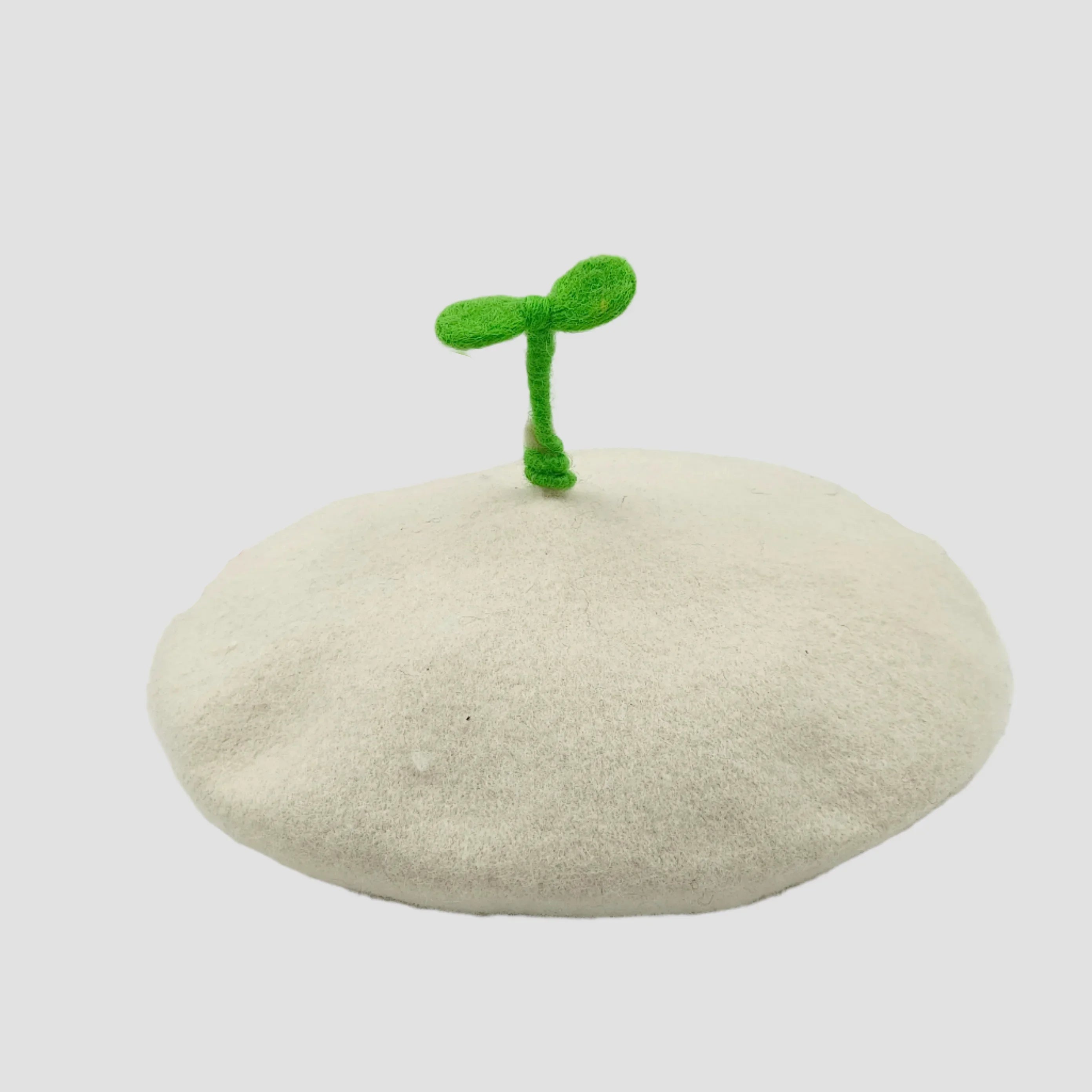 White beret with green sprout.