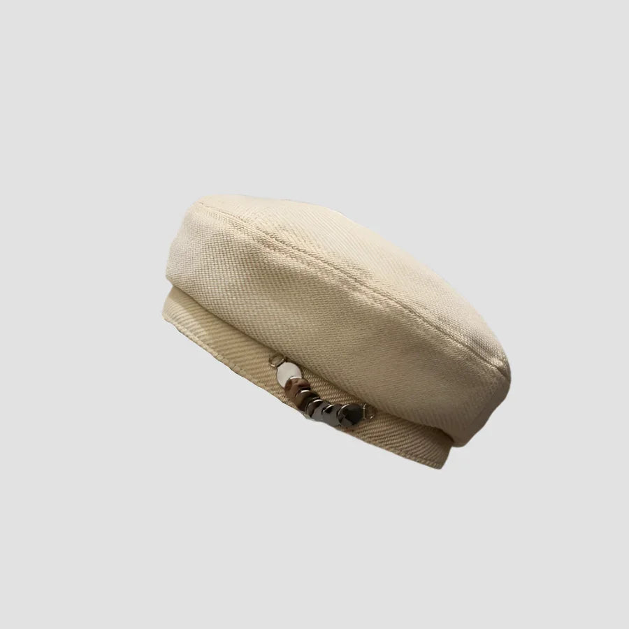 Beige woven beret with decorative beads.
