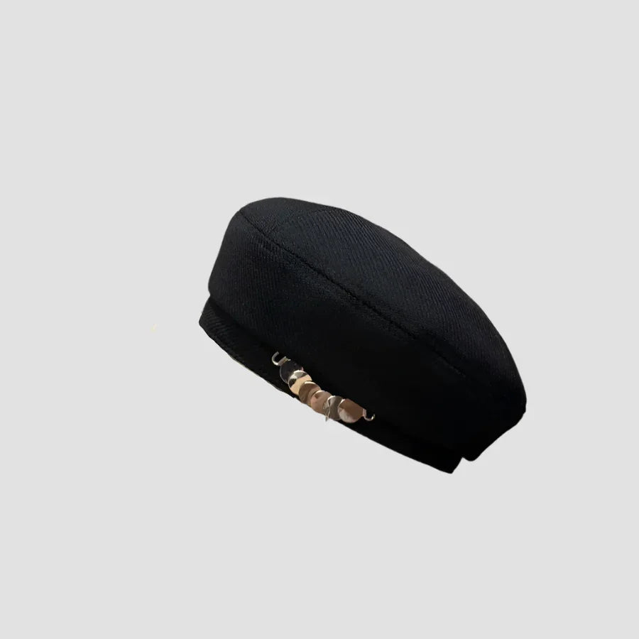 Black beret with gold embellishments.
