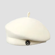 Cream-colored beret with a circular logo.