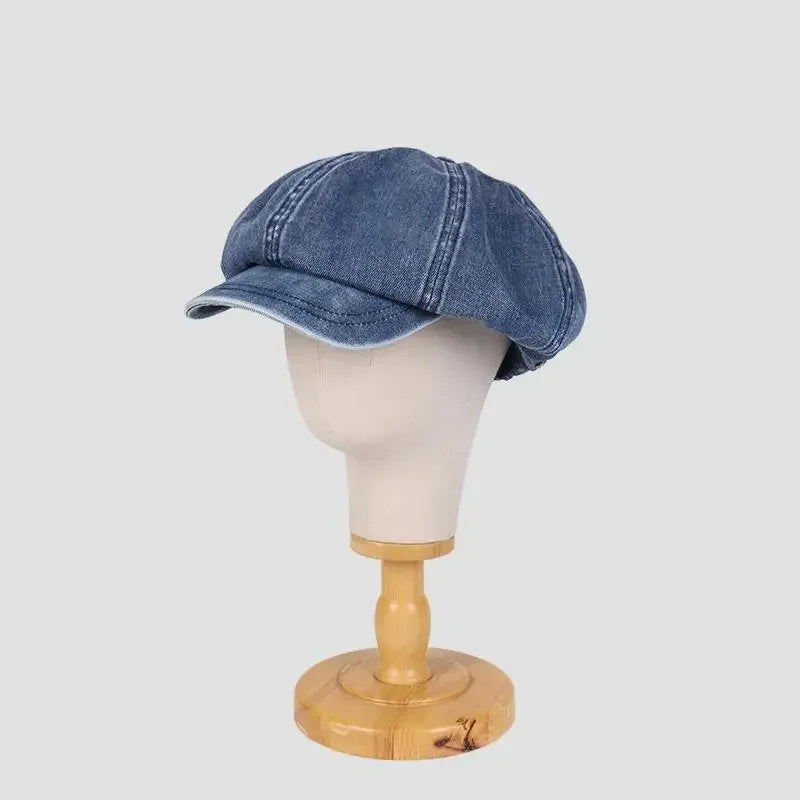 Denim newsboy cap on mannequin head.