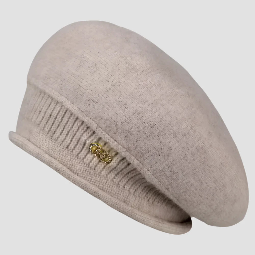 Beige knit beret with decorative embellishment.