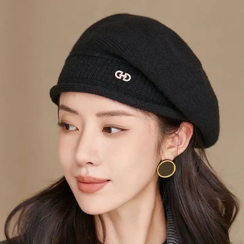Black knit beret with a silver logo.