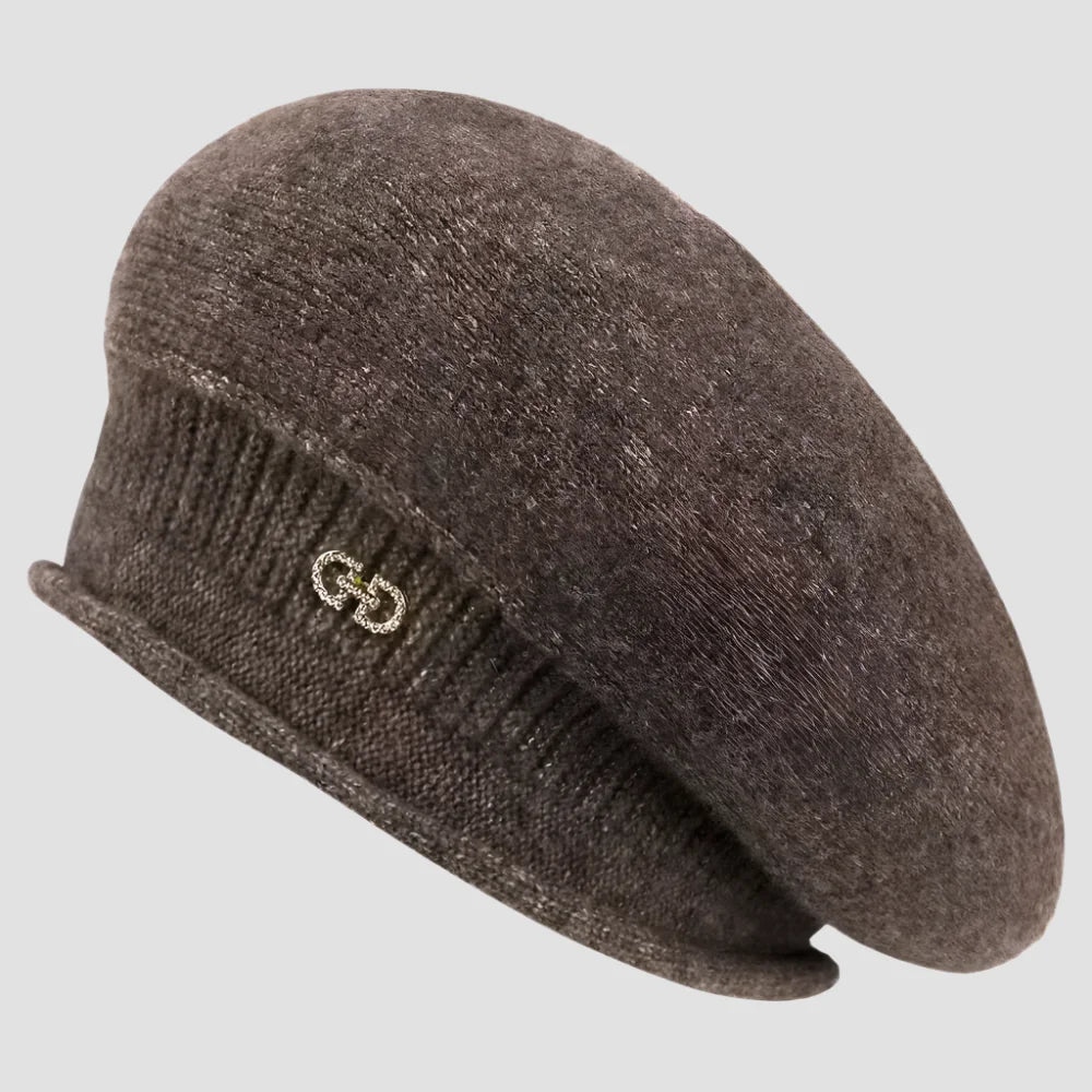 Brown knitted beret with a decorative emblem.