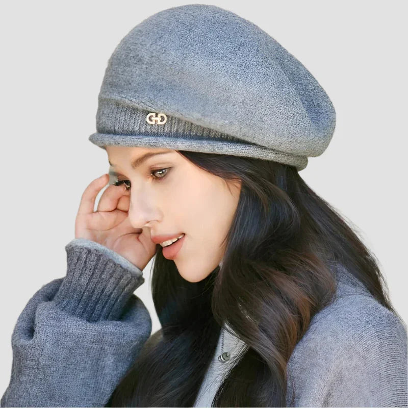 Gray wool beret with decorative emblem.