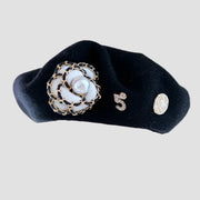 Black beret with flower and number embellishments.