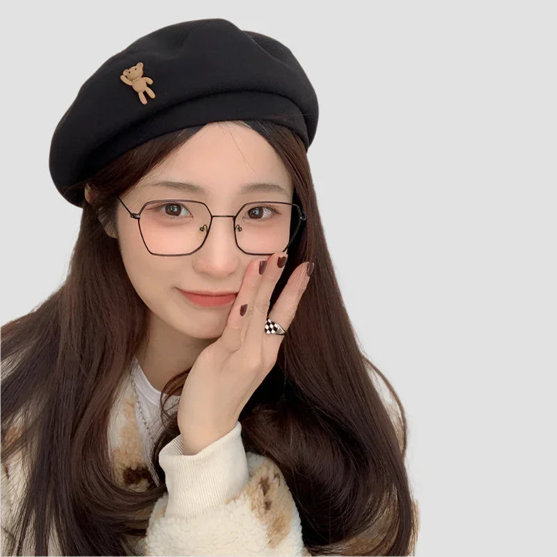 Black beret with teddy bear accent.