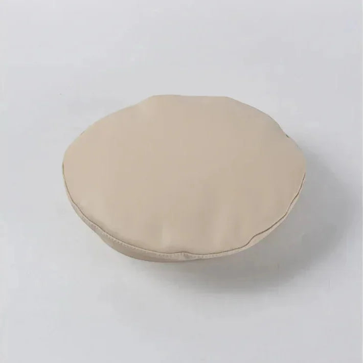 Beige leather beret cushion with soft padded texture and subtle edge stitching