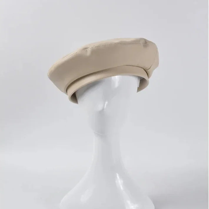 Beige beret on a mannequin head.