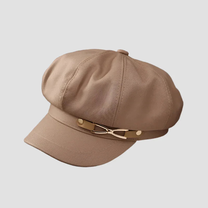 Beige newsboy cap with gold accent.