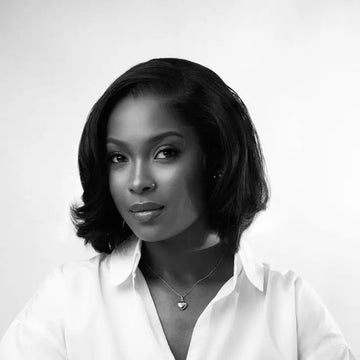 Black and white portrait of a woman wearing a white shirt on a light gray background beret