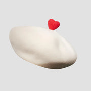 Cream-colored beret with red heart.