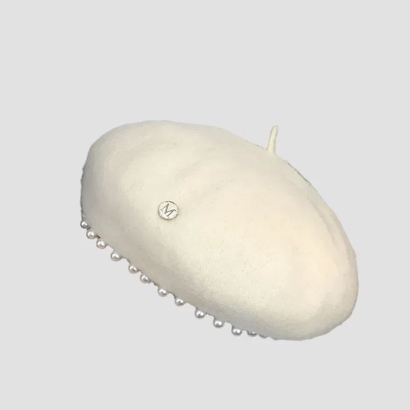 Cream-colored beret with pearl trim.