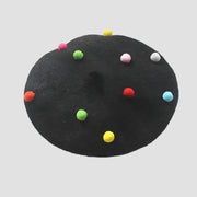 Black beret with colorful pom-poms.