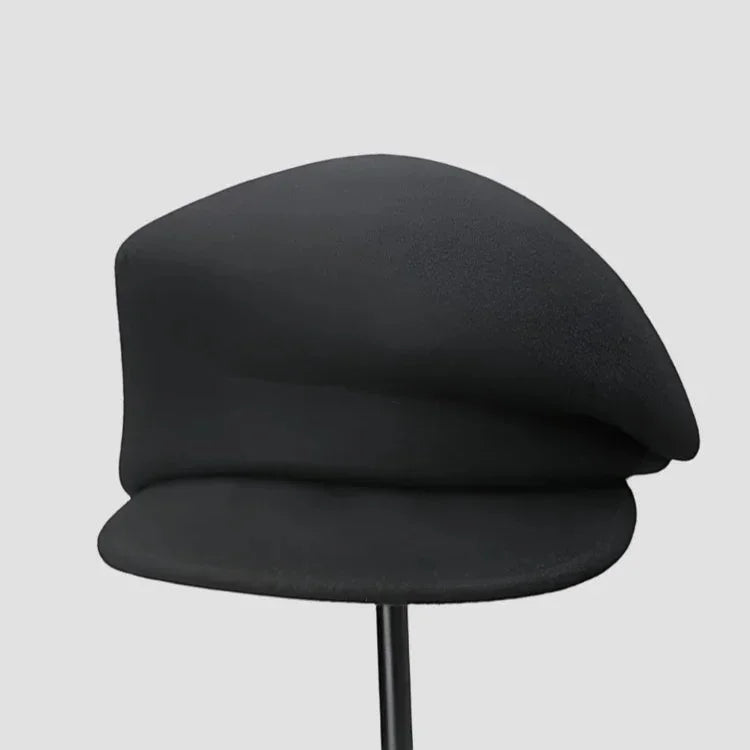 Black wool newsboy cap with soft curved brim and matte finish
