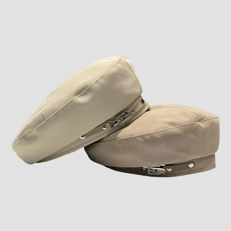 Two beige hats with buckle straps.