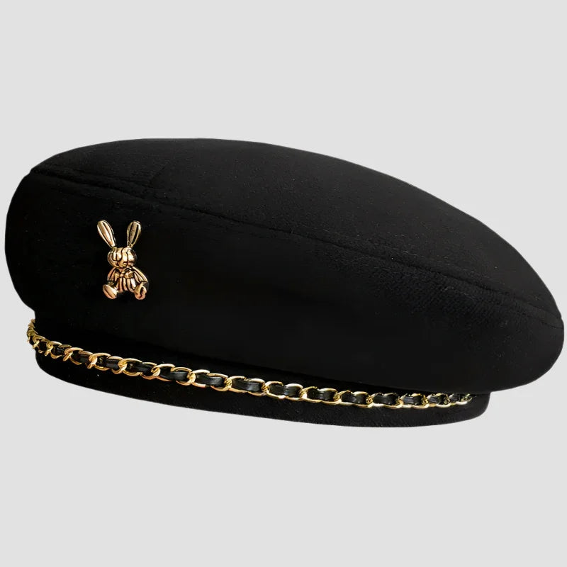 Black beret with gold chain and rabbit pin.