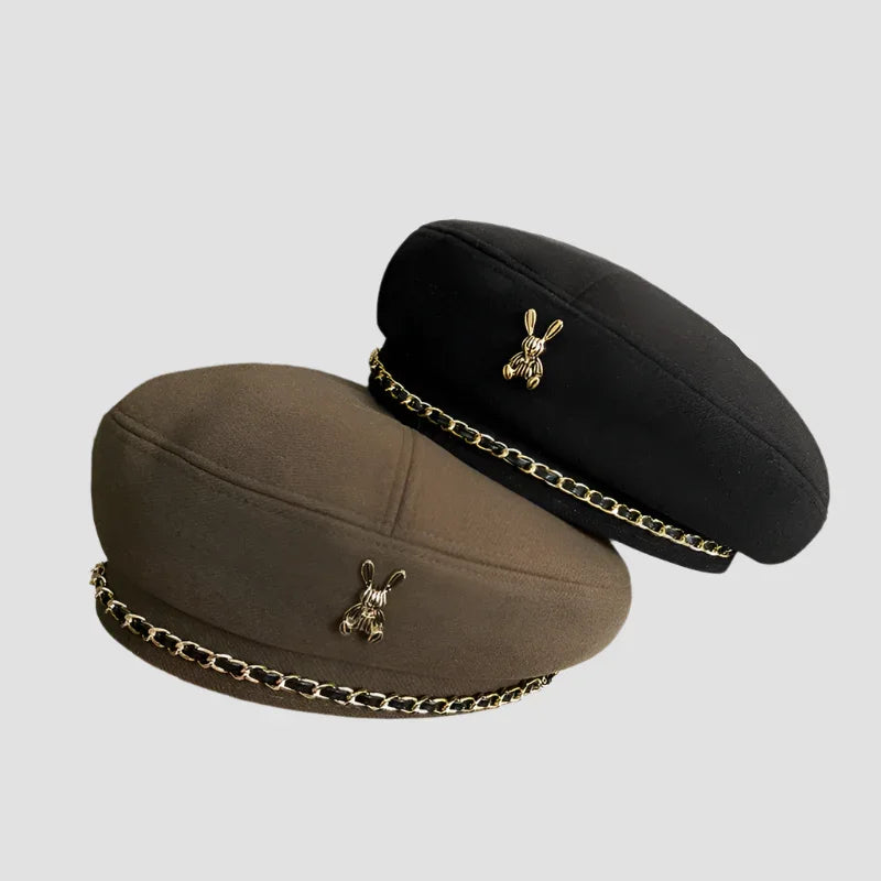Two berets with bunny charms and chain accents.