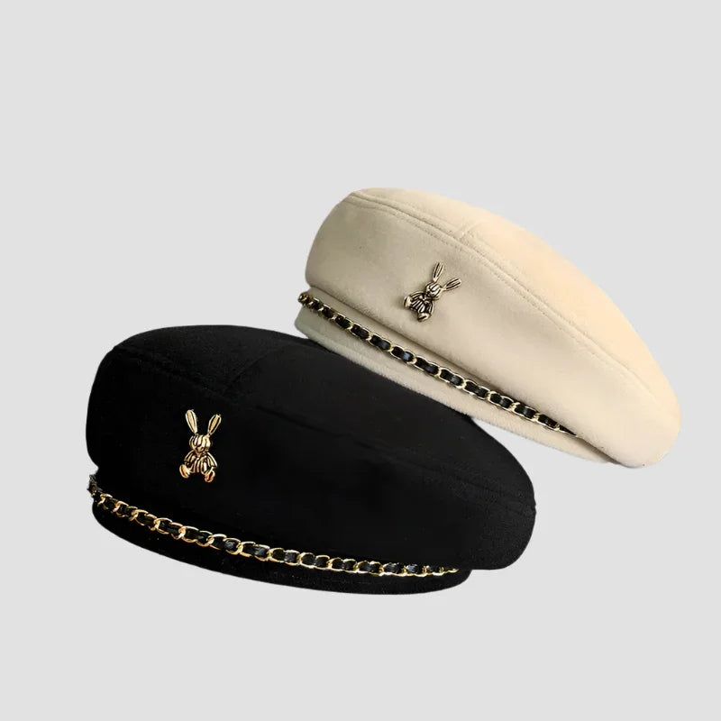Two berets with rabbit brooches and chain trim.