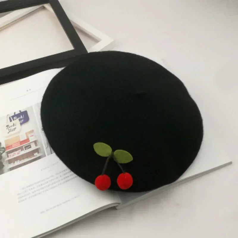 Black beret with cherry embellishments.