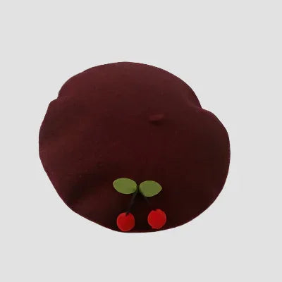 Burgundy beret with cherry embellishments.