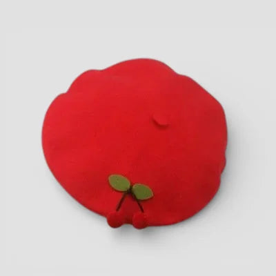 Red pom-pom cherry beret detail with green leaf accents