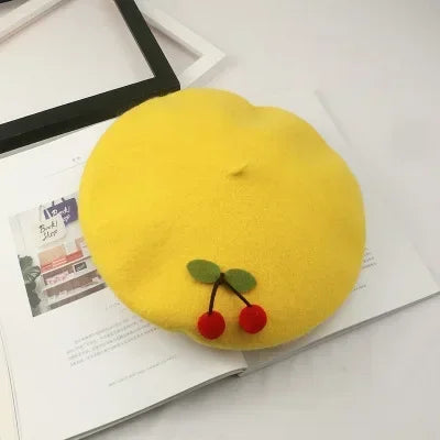 Yellow beret with cherry embellishments.