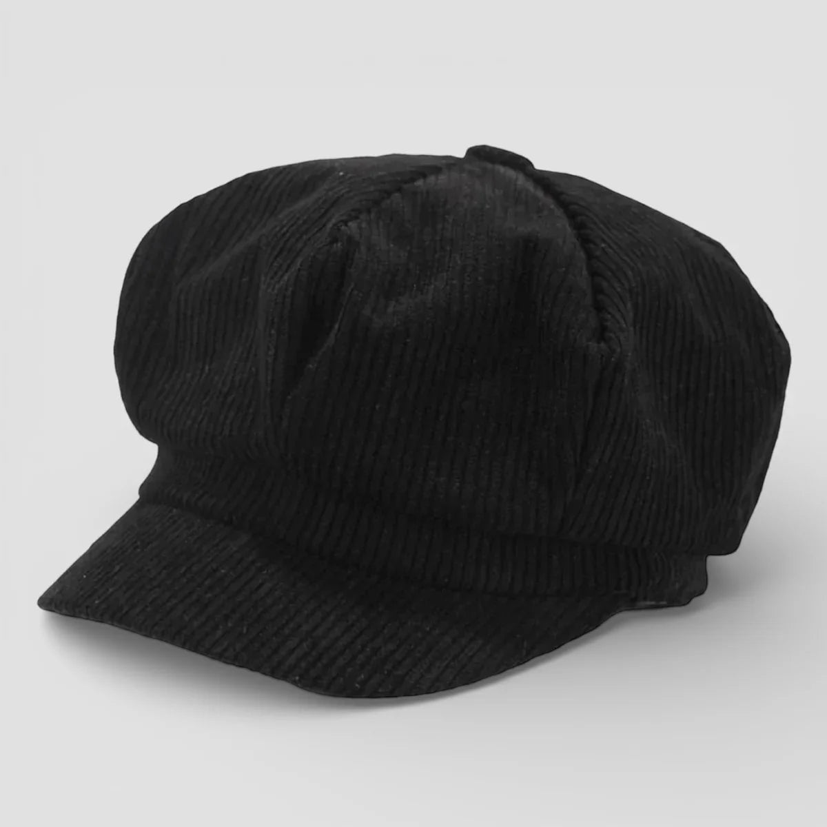 Black corduroy newsboy cap with structured eight-panel design and short brim