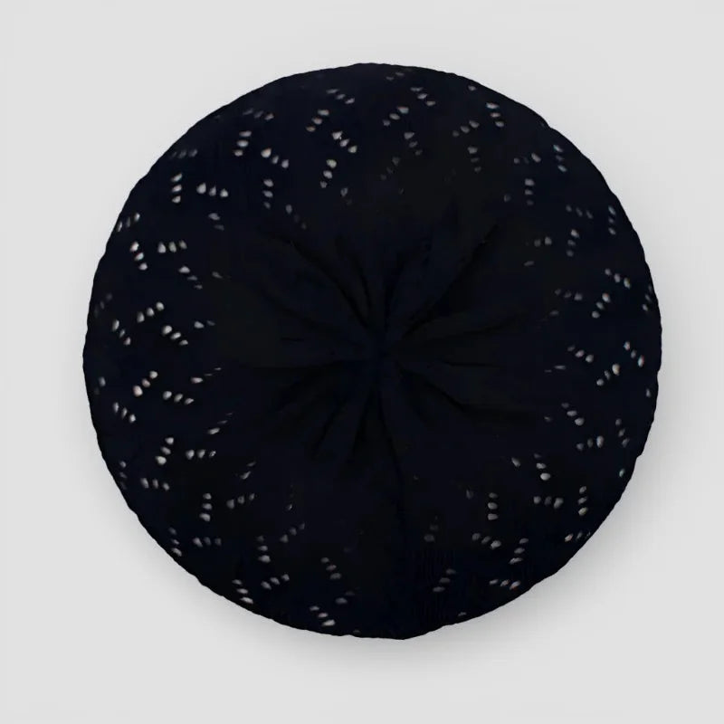 Black crochet beret cushion with white lace perforation pattern