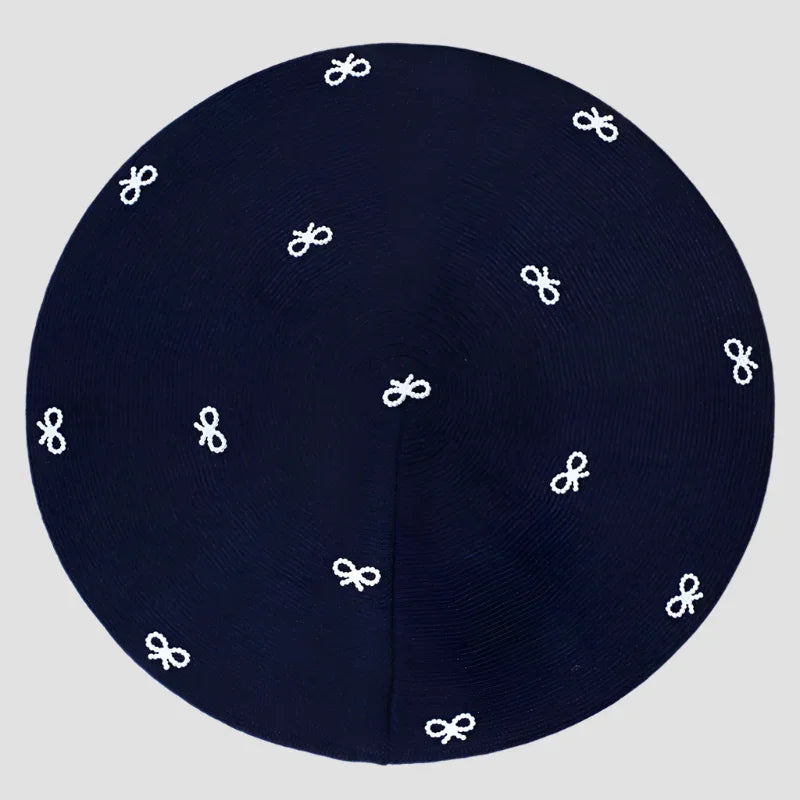 Navy blue kippah with white bow pattern.