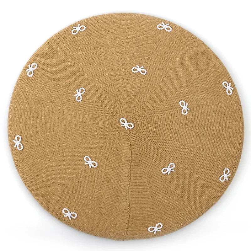 Tan beret with white bow accents.