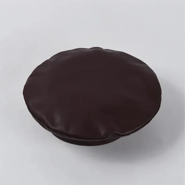 Round, dark brown, leather-like cushion.